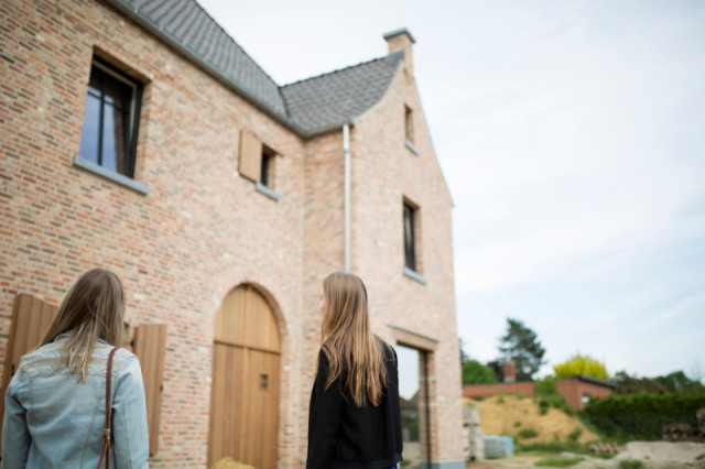 Deux femmes regardent une maison à vendre.